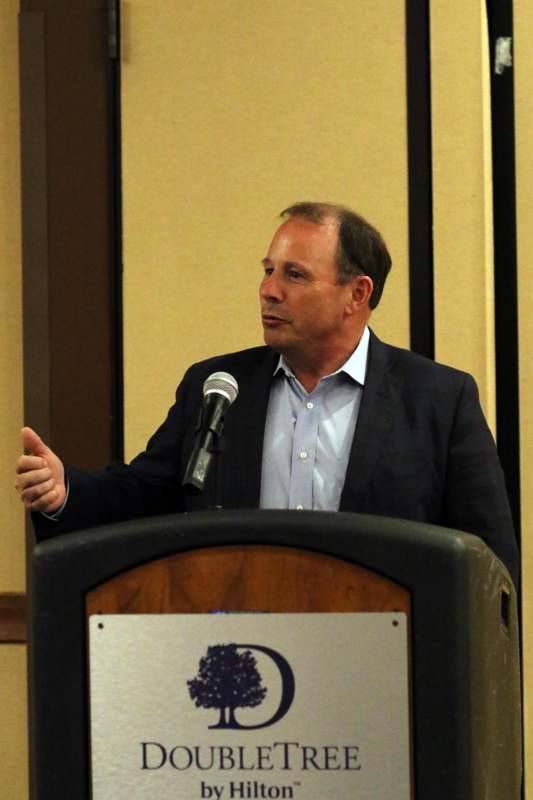 a man standing at a podium speaking into a microphone