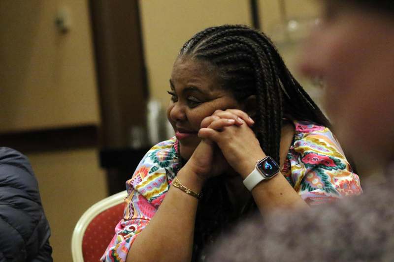 a woman with braids holding her hands to her face