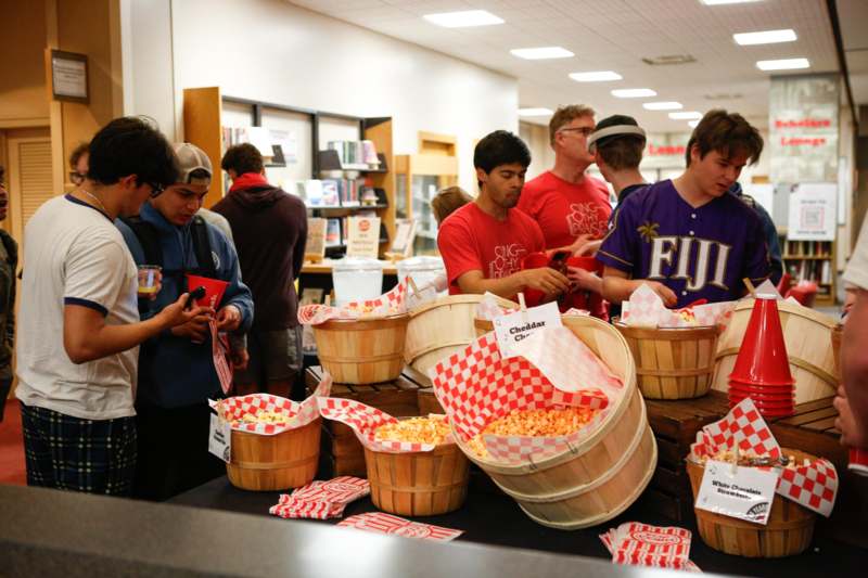 a group of people in a room with baskets of popcorn