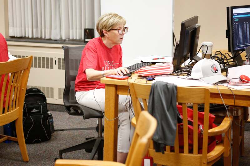 a woman sitting at a desk with a computer
