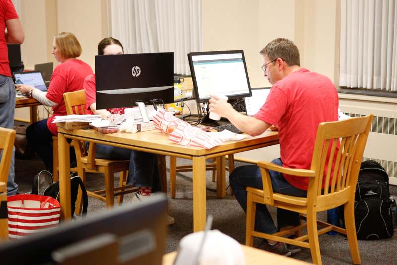 a group of people sitting at a table with computers
