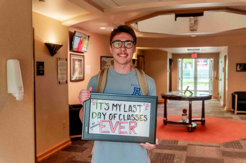 a man holding a sign in a hallway