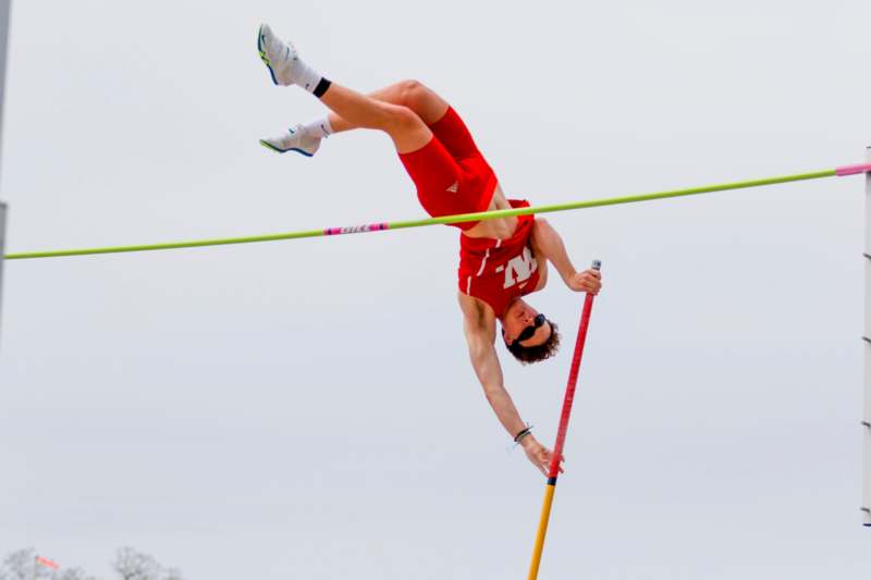 a man jumping over a pole