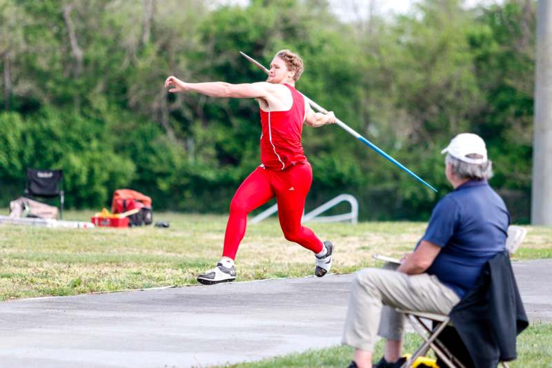 a man in red shirt holding a pole