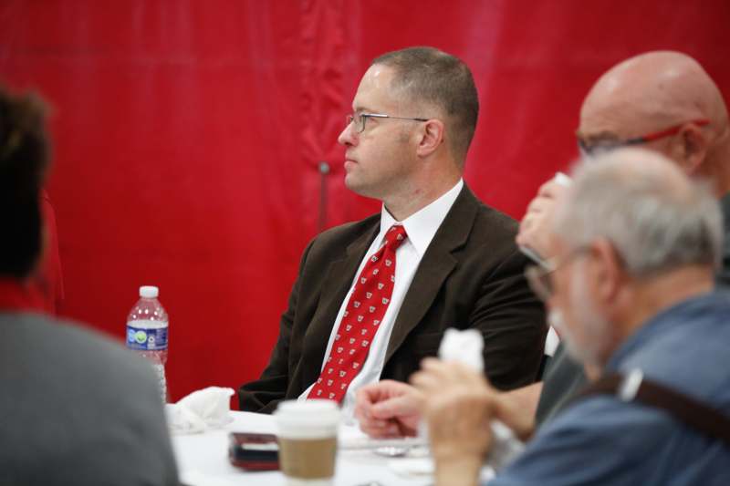 a man in a suit and tie sitting at a table