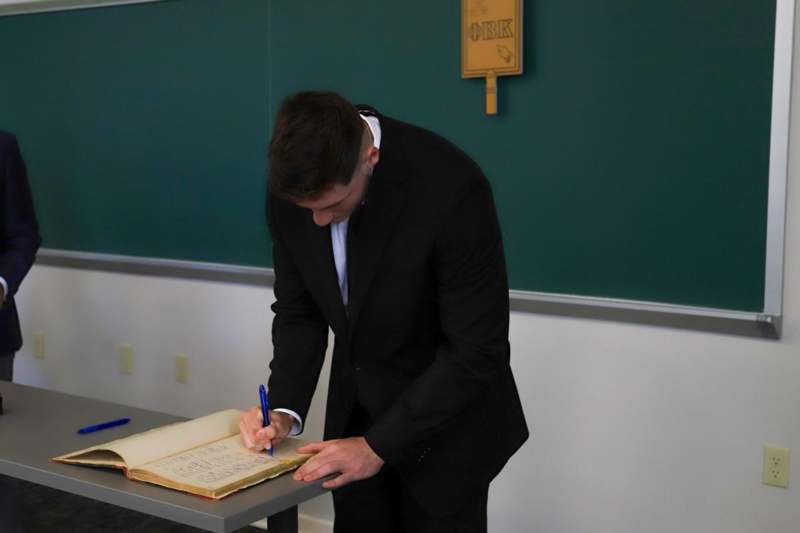 Nicholas Bastian signs the Phi Beta Kappa book.