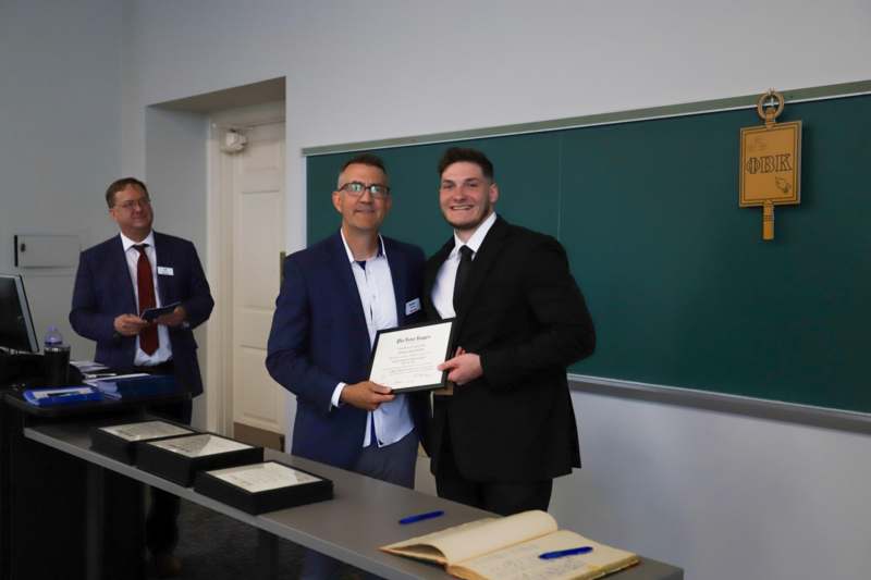 a group of men in suits holding a certificate