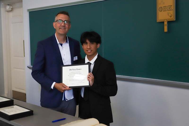 a man and boy holding a certificate