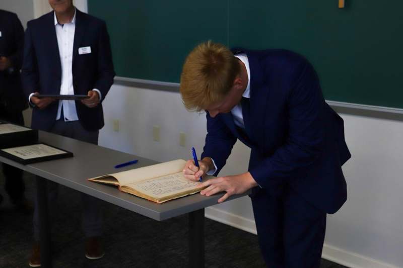 Luka Di Filippo signs the Phi Beta Kappa book.