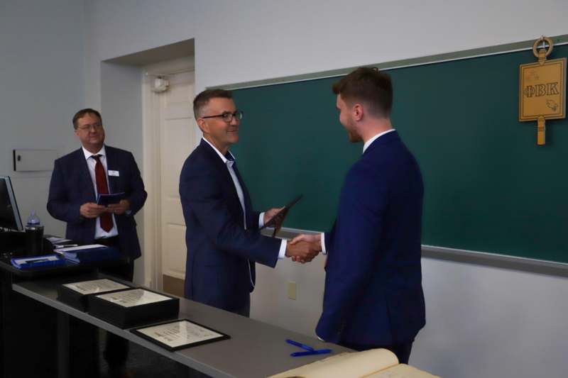 a group of men shaking hands in a classroom