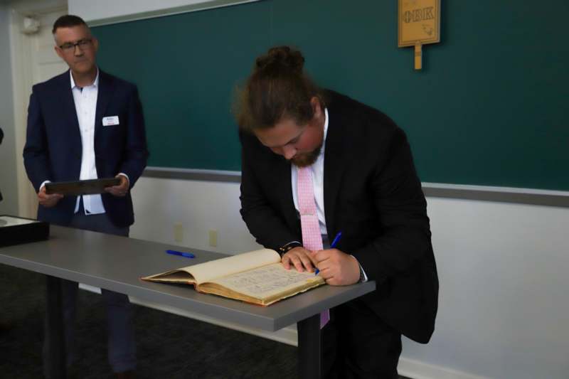 Elijah Greene signs the Phi Beta Kappa book.