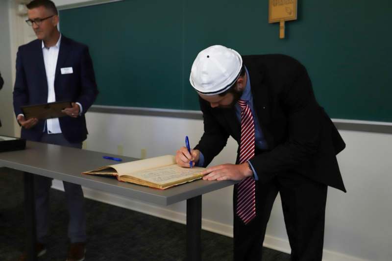 Quinn Manford signs the Phi Beta Kappa book.