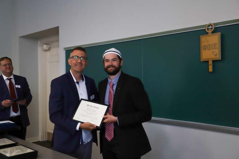 two men holding a certificate