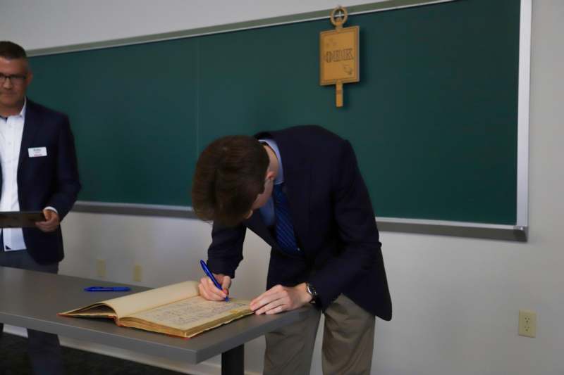 Thomas Oppman signs the Phi Beta Kappa book.