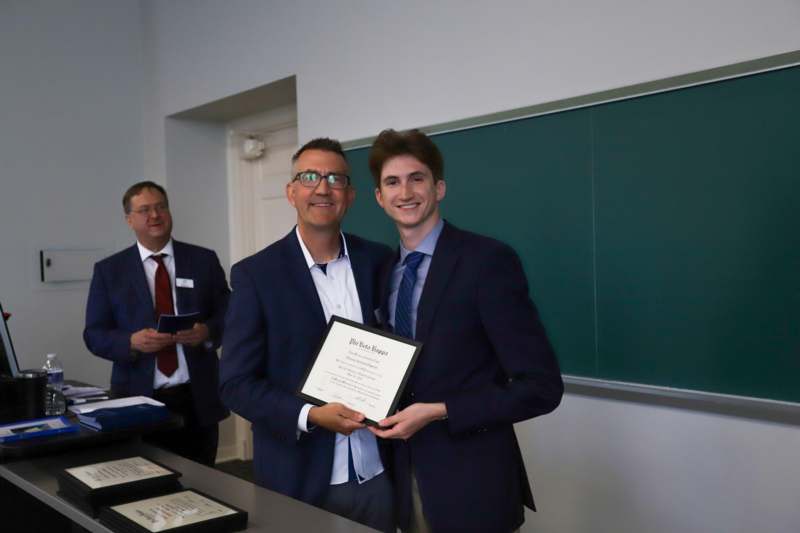 a group of men in suits holding a certificate