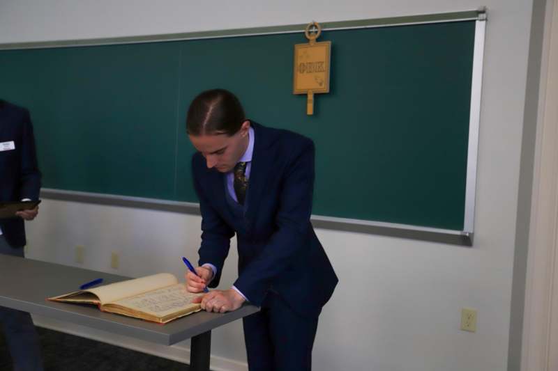 Preston Reynolds signs the Phi Beta Kappa book.