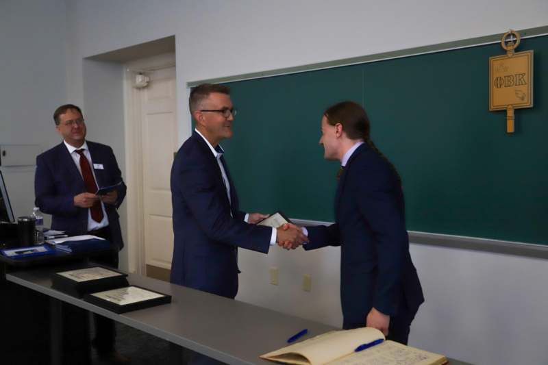 a group of men shaking hands in front of a chalkboard