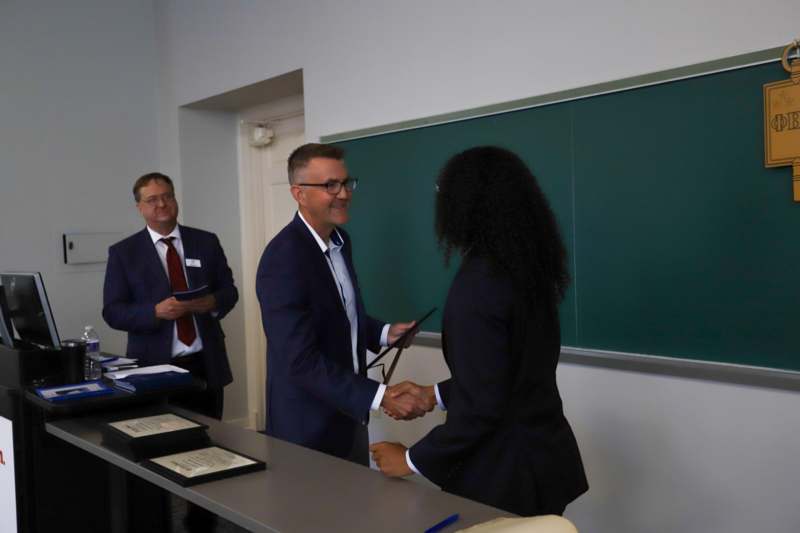a man and woman shaking hands in front of a chalkboard