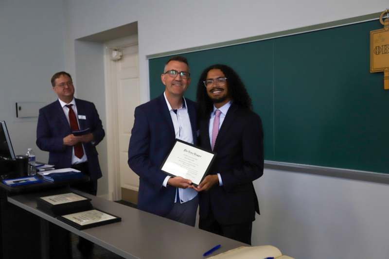 a group of men in suits holding a certificate