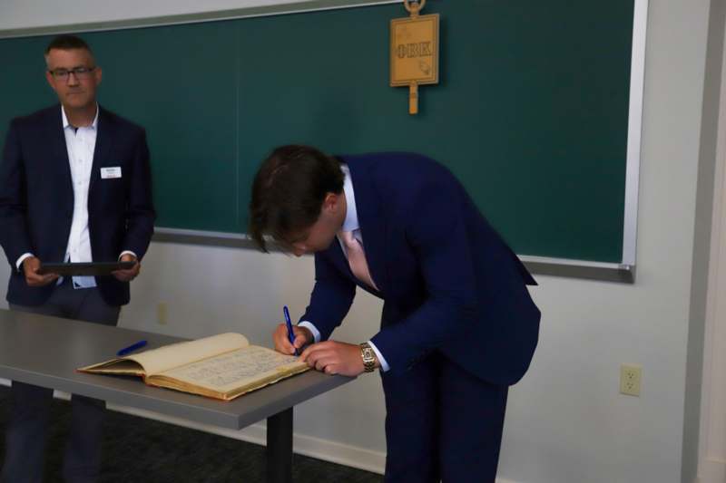 Caden Short signs the Phi Beta Kappa book.
