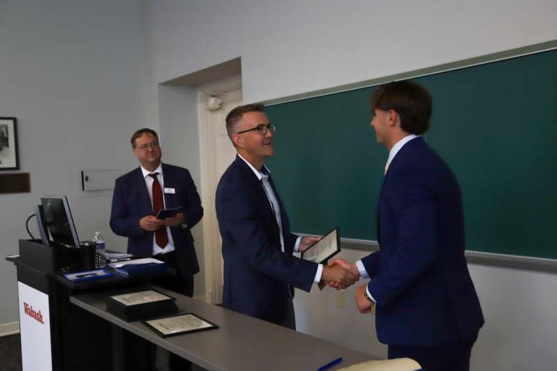 a group of men shaking hands in a classroom