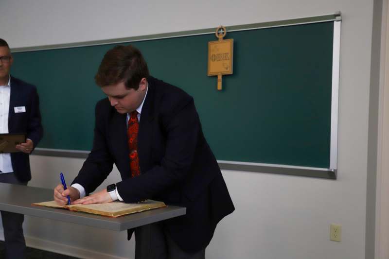 Jacob Weber signs the Phi Beta Kappa book.