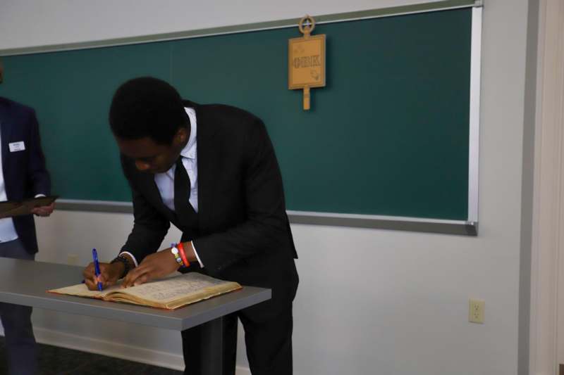 Precious Ainabor signs the Phi Beta Kappa book.