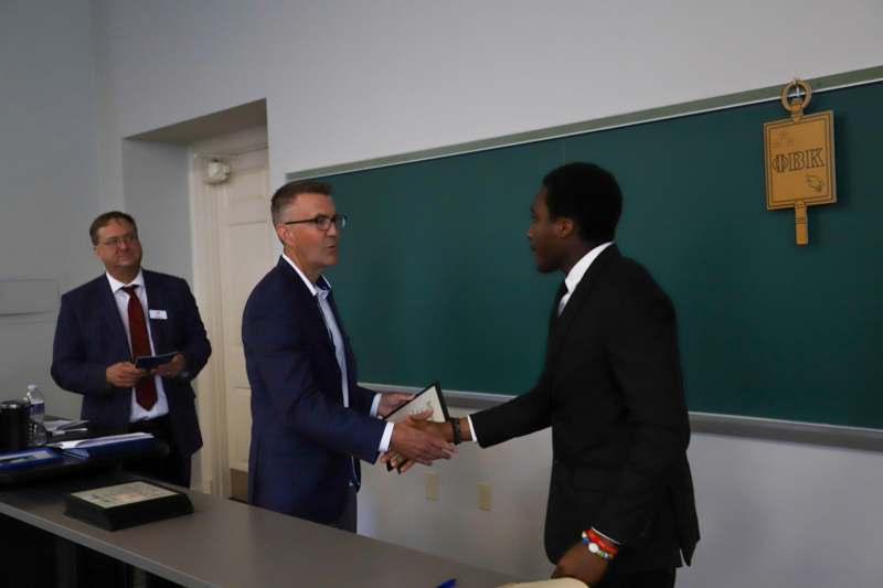 a group of men shaking hands in front of a chalkboard
