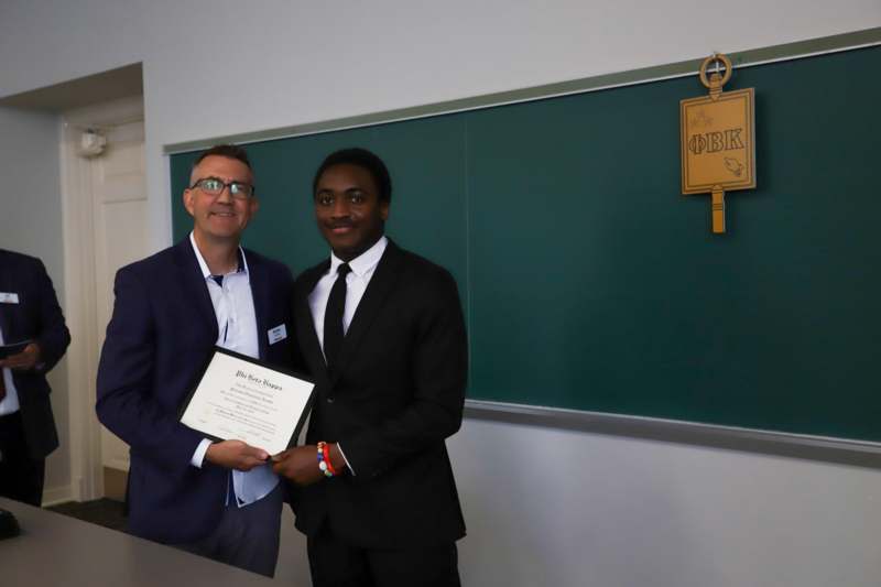 a man holding a certificate and smiling