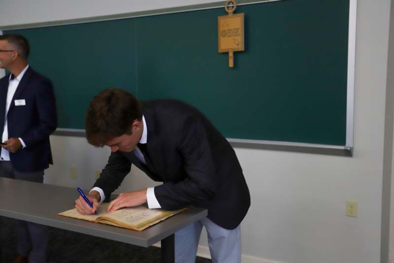 Augusto Ghidini signs the Phi Beta Kappa book.