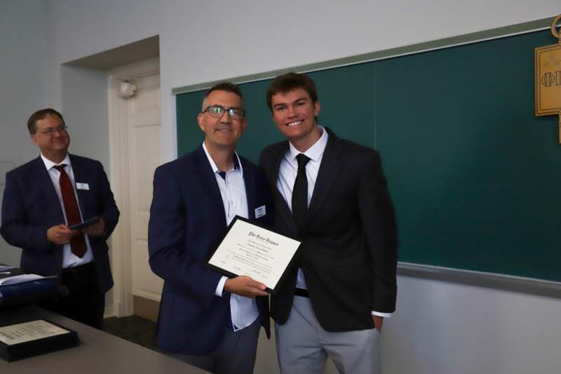 a man holding a certificate and smiling