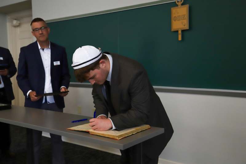 Justin Lewis signs the Phi Beta Kappa book.