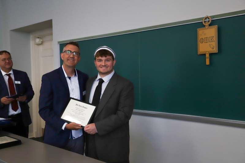 a man holding a certificate and smiling