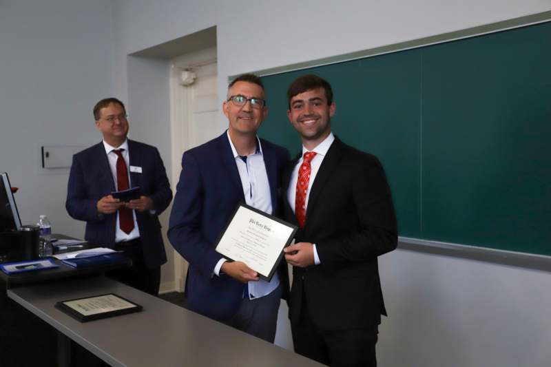 a group of men in suits holding a certificate