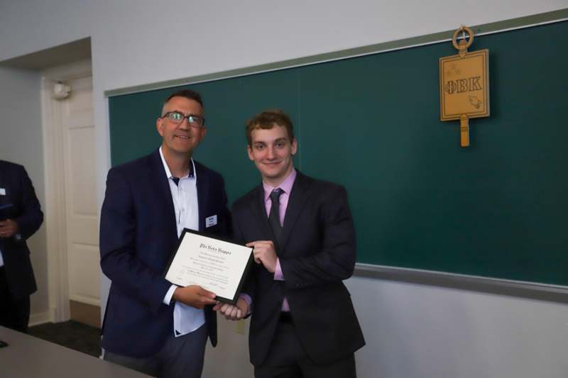 a man holding a certificate and smiling