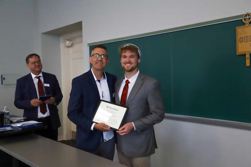 John Schnerre receives his Phi Beta Kappa certificate.