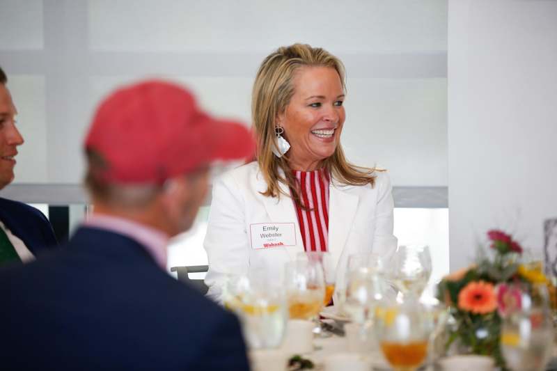 a woman smiling at a table with a group of people