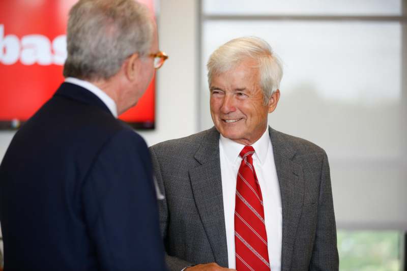 a man in a suit and tie talking to another man