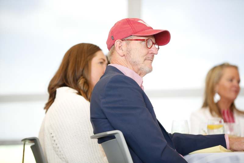 a man in a red hat and glasses sitting in a chair