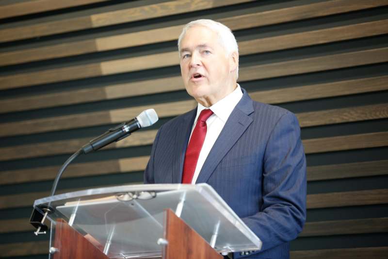 a man standing at a podium with a microphone