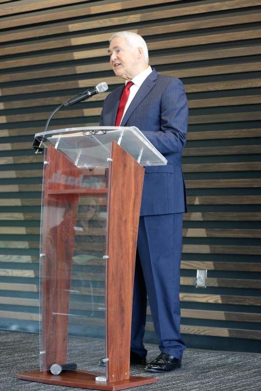 a man standing at a podium speaking into a microphone