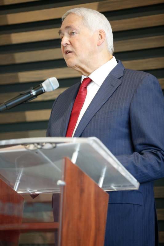 a man standing at a podium speaking into a microphone