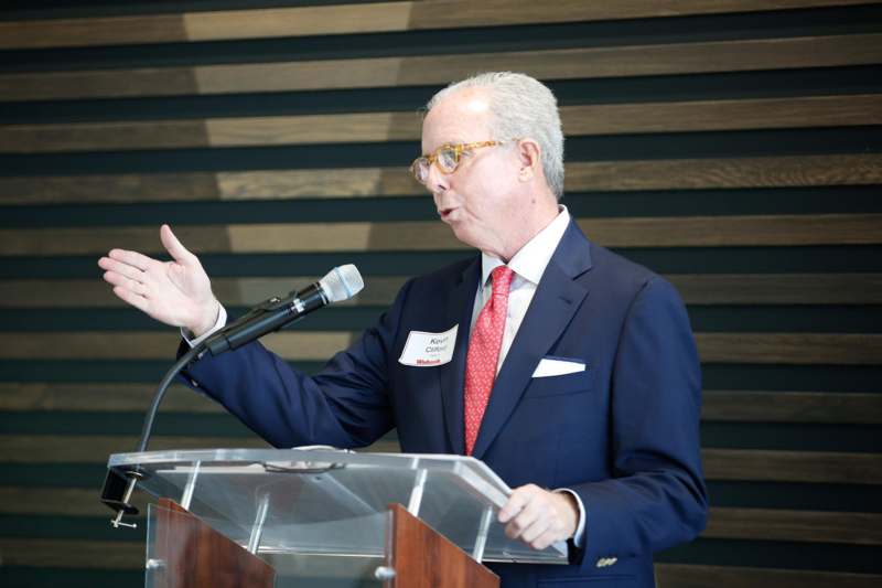 a man standing at a podium speaking into a microphone