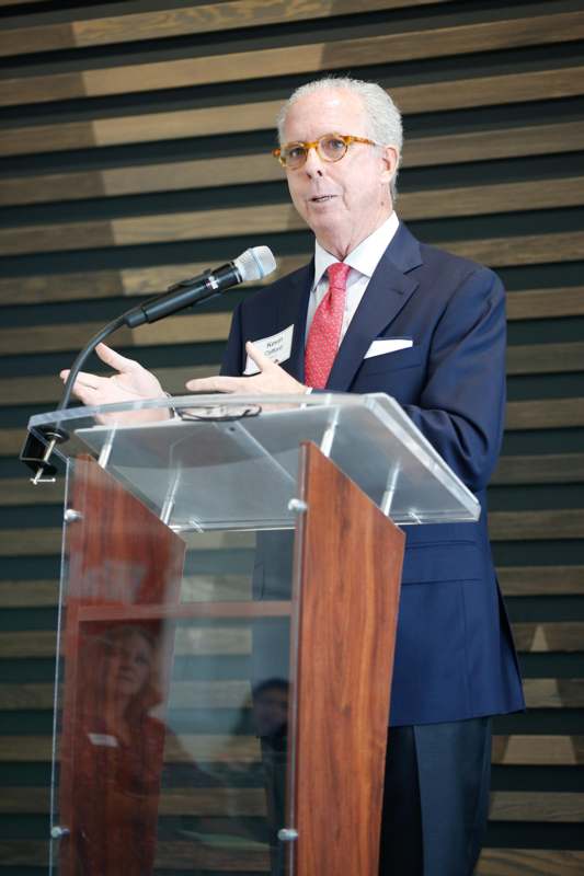 a man standing at a podium speaking into a microphone