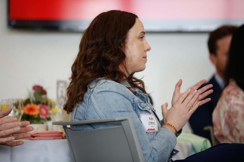 a woman sitting at a table clapping
