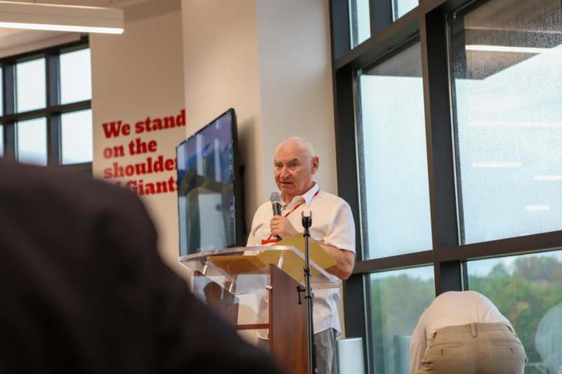 a man standing at a podium speaking into a microphone
