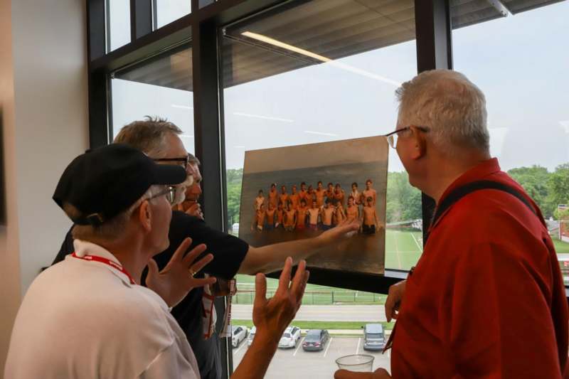 a group of men looking at a picture of a group of people