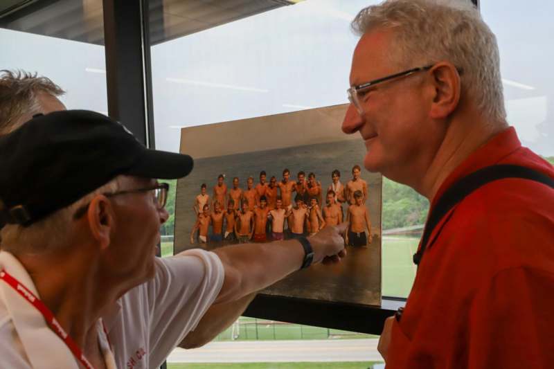 a man pointing at a picture of a group of men