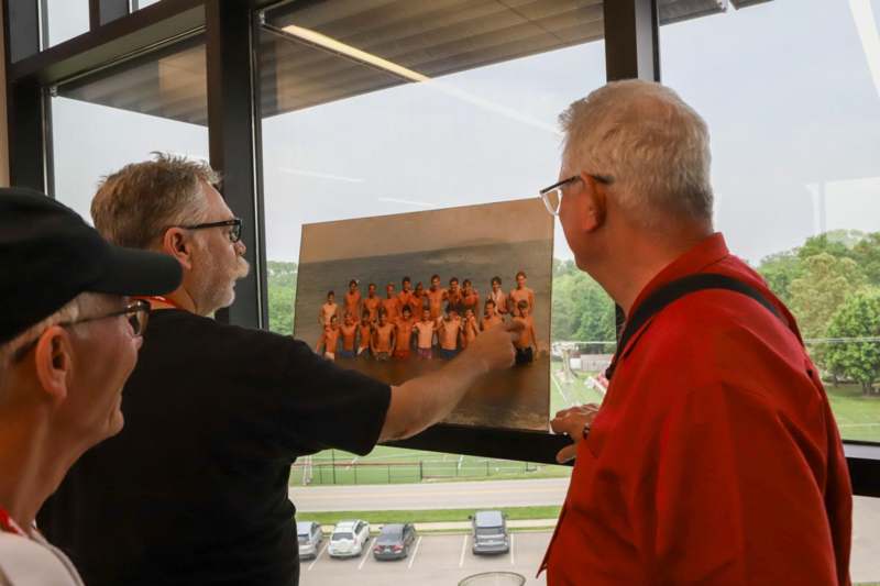 a man pointing at a picture of a group of people