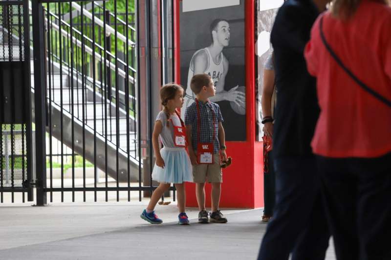 a boy and girl walking in front of a poster